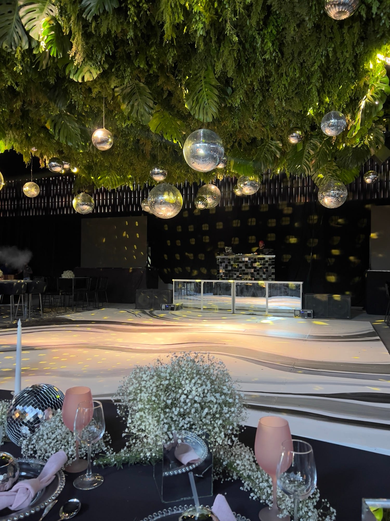 Pista de baile con esferas de espejos y techo de follaje verde